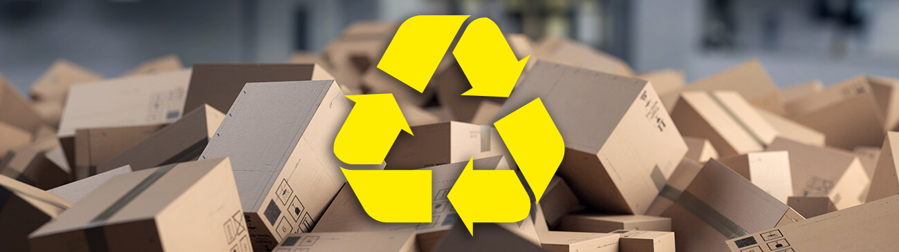 Ein Recycling Symbol im Vordergrund und Kartonschachteln im Hintergrund